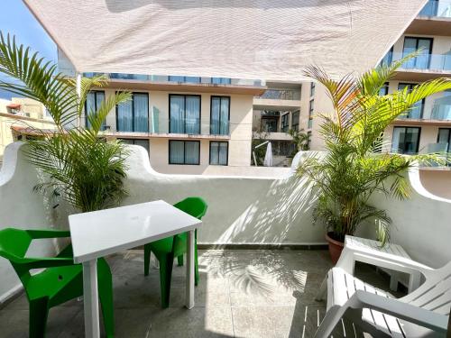 uma varanda com uma mesa e cadeiras e um edifício em Miranda Beach em Playa del Carmen
