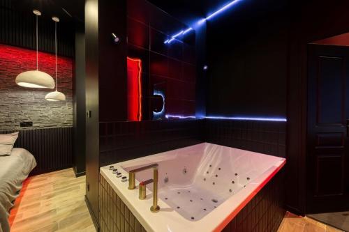une salle de bain avec une baignoire avec un éclairage rouge dans l'établissement Suite Deluxe - Jacuzzi, à Melun