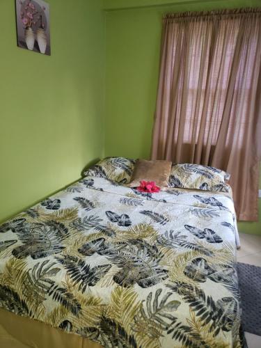 a bed with a comforter with a flower on it at SK S Haven #1 in Castries