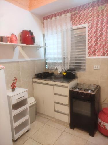 Il comprend une petite cuisine équipée d'un évier et d'une cuisinière. dans l'établissement Chalezinho em São Bernardo Campo com vaga, à São Bernardo do Campo