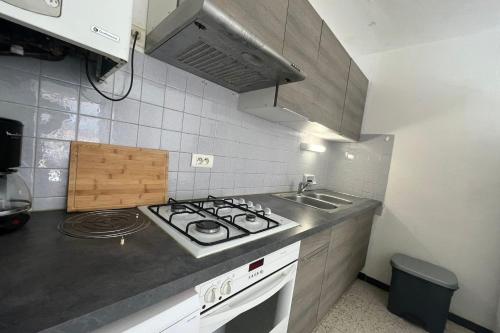 une cuisine avec une cuisinière et un évier dans l'établissement Spacious nest with sea view, à Port-la-Nouvelle