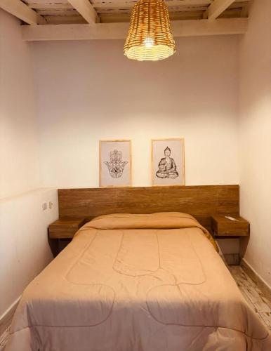 a bedroom with a bed and two pictures on the wall at Casa Blanca in Santiago del Estero