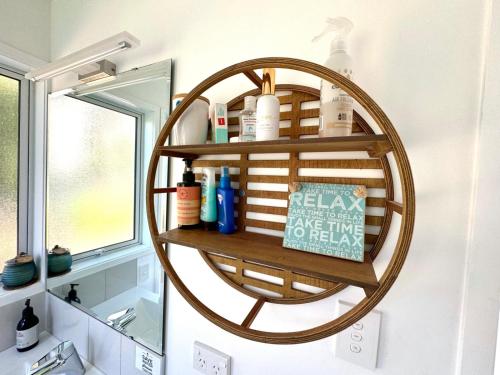 a bathroom with a round shelf on the wall at Four Huia in Oneroa
