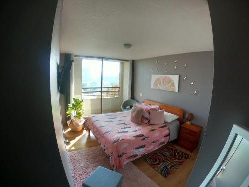 um pequeno quarto com uma cama e uma janela em Departamento 2 Dormitorios Santiago em Santiago