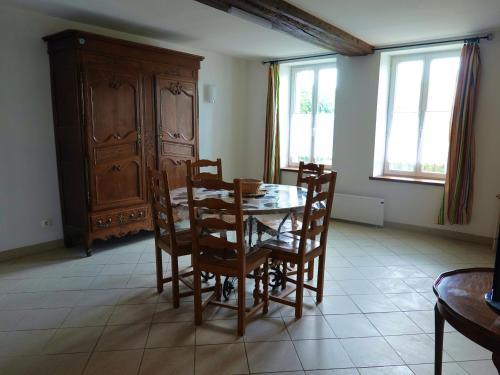 une salle à manger avec une table et des chaises en bois dans l'établissement Maison confortable avec cour, proche du Château de La Bussière, idéale pour explorations. - FR-1-590-161, à La Bussière