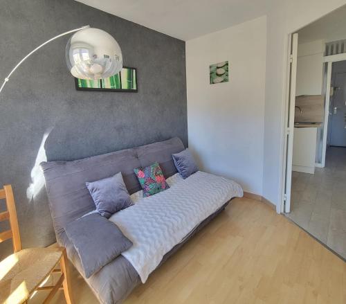 um sofá com almofadas numa sala de estar em Beautiful T3 with balcony - near beach em Fréjus