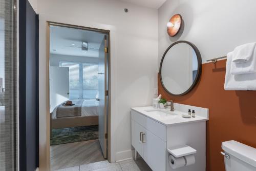 a bathroom with a sink and a mirror at Outrider 105 by AvantStay Near Broadway Downtown in Nashville