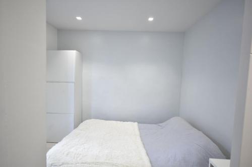 - une petite chambre blanche avec un lit et une table de chevet dans l'établissement Nice 37 m with garden in Marseille, à Marseille