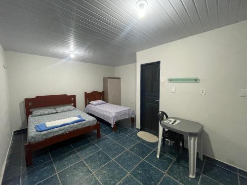 a room with two beds and a table in it at Canto da Liberdade in Boa Vista
