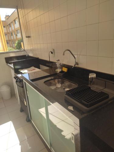 uma cozinha com um lavatório e uma bancada em Claudia Apartment em Vila Velha