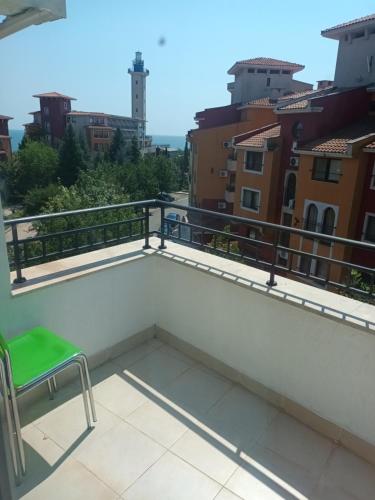a chair on a balcony with a view of the city at Relaks w Marina Cape 88 in Aheloy