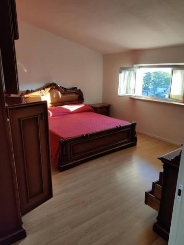 ein Schlafzimmer mit einem Bett mit einer roten Bettdecke und einem Fenster in der Unterkunft Attico Mansardato in San Salvo