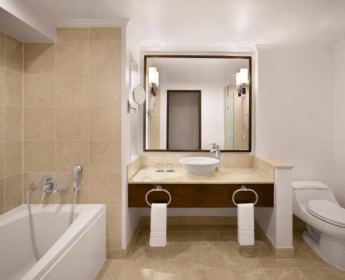 杜夢的住宿－關島威斯汀度假酒店，一间带水槽、浴缸和卫生间的浴室
