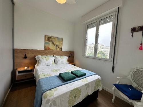 um quarto com uma cama e uma janela em Bela vista no Leblon - a 2 quadras da praia no Rio de Janeiro