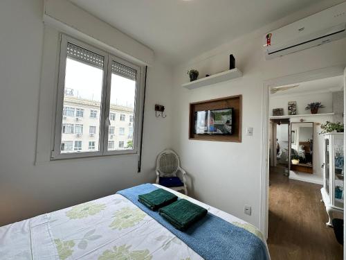 um quarto com uma cama e duas janelas em Bela vista no Leblon - a 2 quadras da praia no Rio de Janeiro