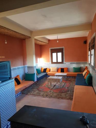 een woonkamer met banken en een tafel in een kamer bij Auberge Assays in Taliouine