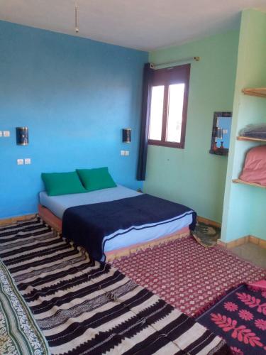 1 dormitorio con cama y alfombra en Auberge Assays, en Taliouine