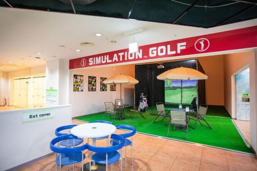 a room with a table and chairs and a golf ball at Hotel Resol Hakodate in Hakodate