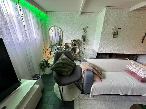 ein Schlafzimmer mit einem Bett, einem Stuhl und einem TV in der Unterkunft Stenkällevägen 60 in Malmö