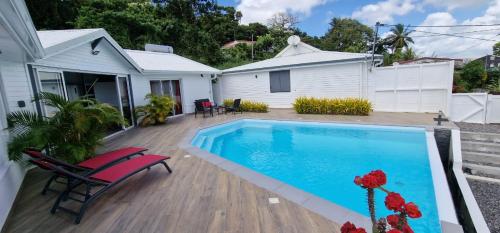 Ducos的住宿－La villa Tina，一个带游泳池和房子的后院