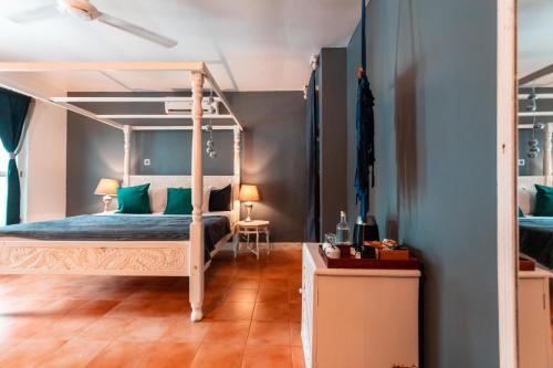 a bedroom with a canopy bed with green pillows at B4 BOUTIQUE in Paje