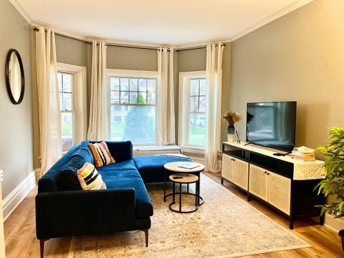 a living room with a blue couch and a flat screen tv at Lovely vintage Oak Park 3bd 1ba perfectly located near public transit & Chicago in Oak Park