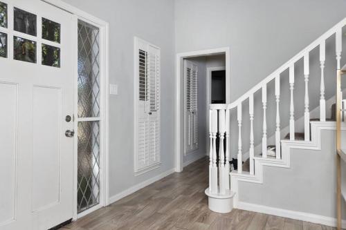 a white staircase in a home with white walls at Houston Luxury 4br/3ba and Pool in Sugar Land