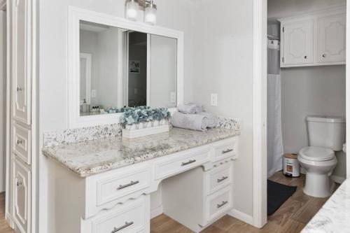 a white bathroom with a sink and a mirror at Houston Luxury 4br/3ba and Pool in Sugar Land