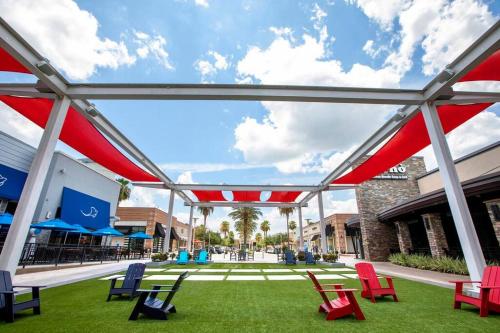 a patio with red and blue chairs on the grass at Houston Luxury 4br/3ba and Pool in Sugar Land