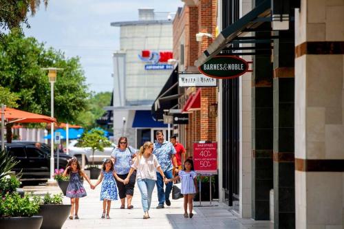 a family walking down a street holding hands at Houston Luxury 4br/3ba and Pool in Sugar Land