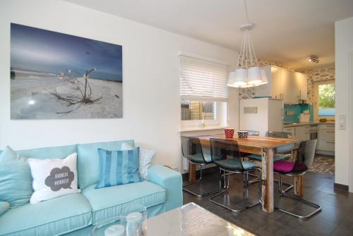 ein Wohnzimmer mit einem blauen Sofa und einem Tisch in der Unterkunft Ferienhaus Westhüs in Tinnum