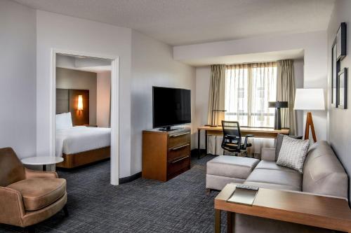 a hotel room with a couch and a tv at Residence Inn by Marriott Birmingham Downtown UAB in Birmingham