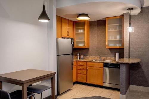 a kitchen with wooden cabinets and a stainless steel refrigerator at Residence Inn by Marriott Birmingham Downtown UAB in Birmingham