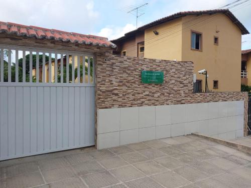 un garaje con una valla blanca y una casa en Residencial Jardins Ilha de Itamaracá, en Vila Velha