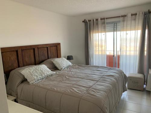 Un dormitorio con una cama grande y una ventana en La mano, en Punta del Este