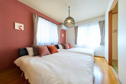 two beds in a room with red walls at The Prime TOKYO HANEDA in Tokyo