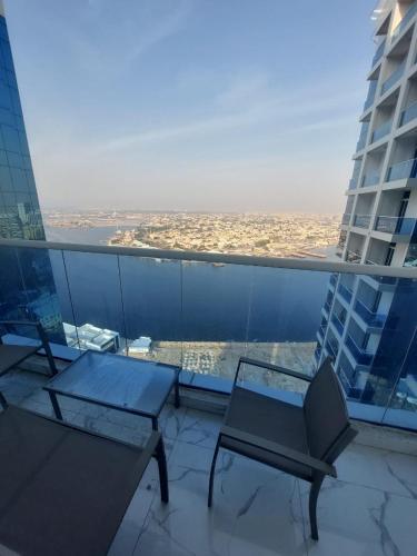 a balcony with a table and chairs on a building at Oasis tower family apartment 2302 in Ajman