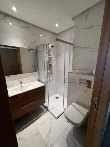 a bathroom with a shower and a toilet and a sink at ZS house harhoura vue sur piscine in Temara