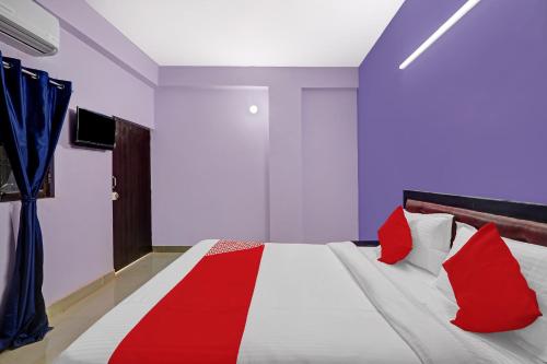 1 dormitorio con 1 cama grande con almohadas rojas en OYO Flagship 24 Stays, en Chinhat