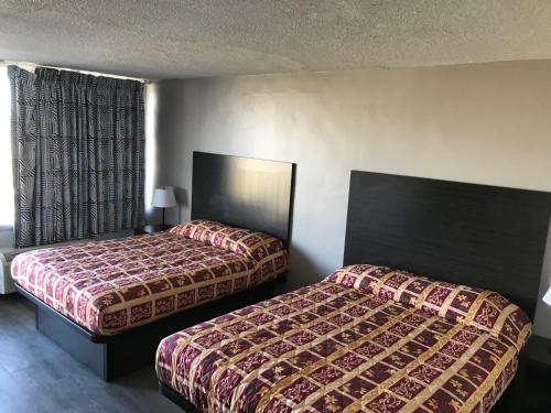 Кровать или кровати в номере Delux Inn