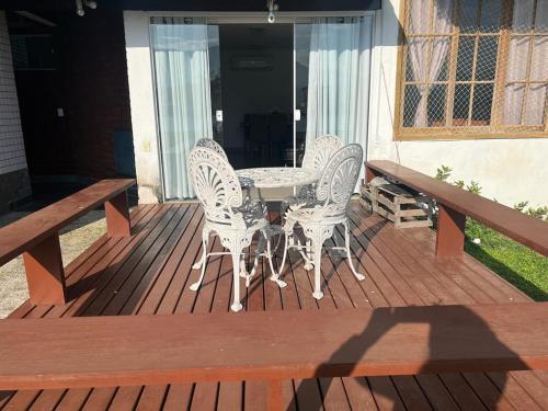 a patio with a table and chairs on a deck at Lindo apartamento em angra dos reis in Angra dos Reis