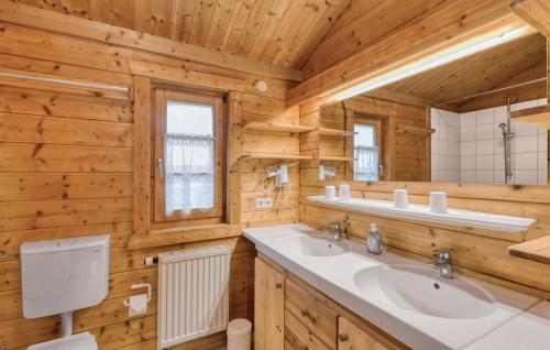 un bagno con due lavandini in una cabina di legno di Ferienhaus Tauber 17 a Hayingen