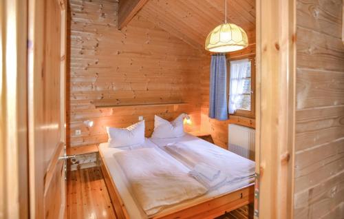 una camera con un letto in una cabina di legno di Ferienhaus Tauber 60 a Hayingen