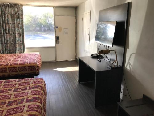 una camera d'albergo con letto e TV di Delux Inn a Macon