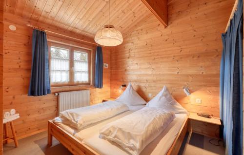 a bedroom with a bed in a wooden room at Ferienhaus Tauber 82 in Hayingen