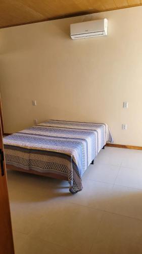 a bed sitting in a room with a radiator at Apartamento a 50 m aeroporto de Ilhéus in Ilhéus