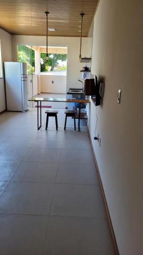 ein Esszimmer mit einem Tisch und einem Kühlschrank in der Unterkunft Apartamento a 50 m aeroporto de Ilhéus in Ilhéus