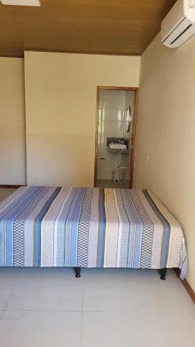 a bedroom with a bed with a striped blanket at Apartamento a 50 m aeroporto de Ilhéus in Ilhéus