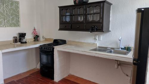 uma cozinha com um lavatório e um fogão em La casa 19 em Cancún