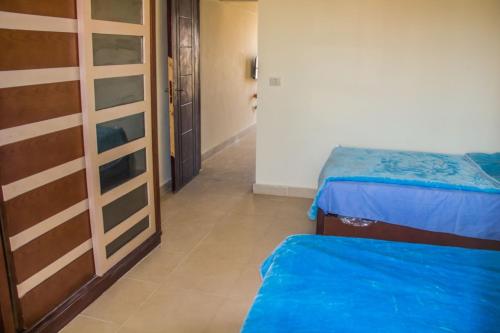 Habitación con 2 camas y pasillo. en APARTMENT LASIRENA MINI EGYPT-FAMILY-By Lasirena Group, en Ain Sokhna